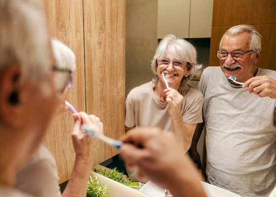 Patient in Garner smiling with partner while brushing