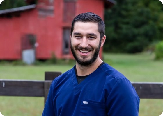 Doctor Samia smiling with red house in background