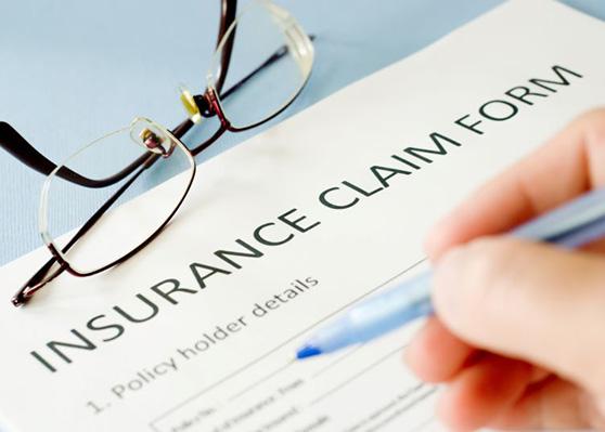 Person filling out insurance claim form