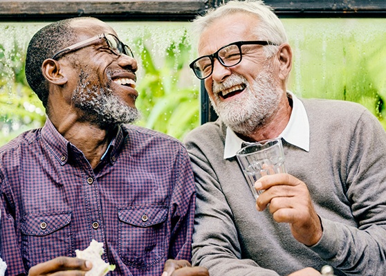 Patient in Garner smiling with friend in dentures