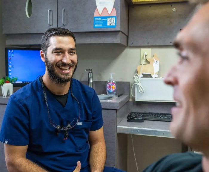 Doctor Samia laughing with a dental patient in the treatment chair