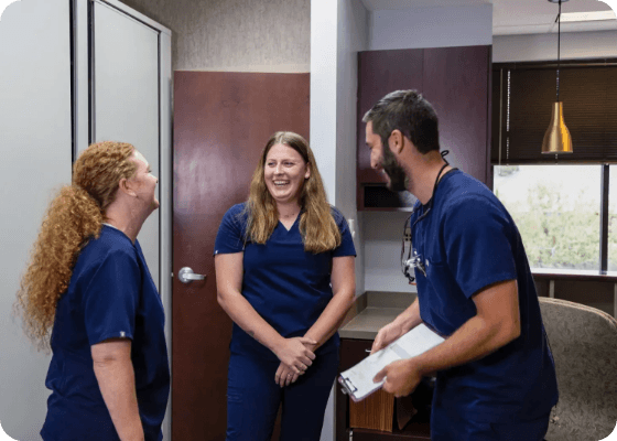 Doctor Samia laughing with two dental team members