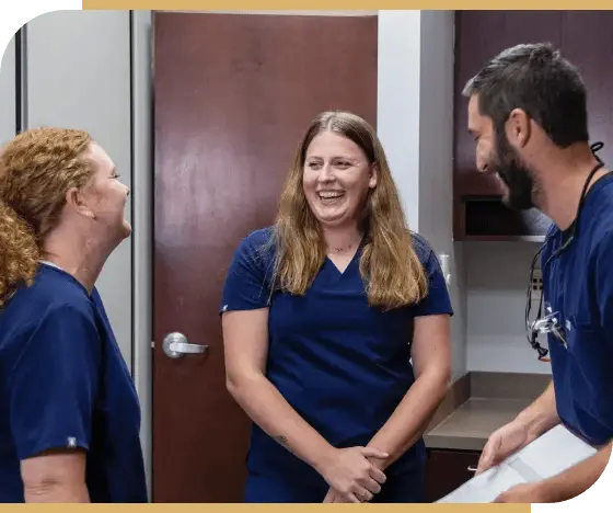 Doctor Samia laughing with two dental team members