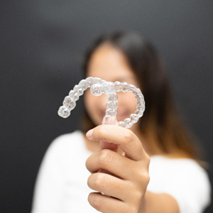 Woman holding two clear aligners