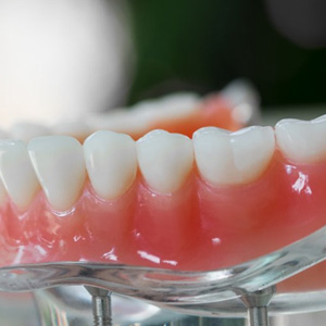 A lower denture resting on a clear display stand