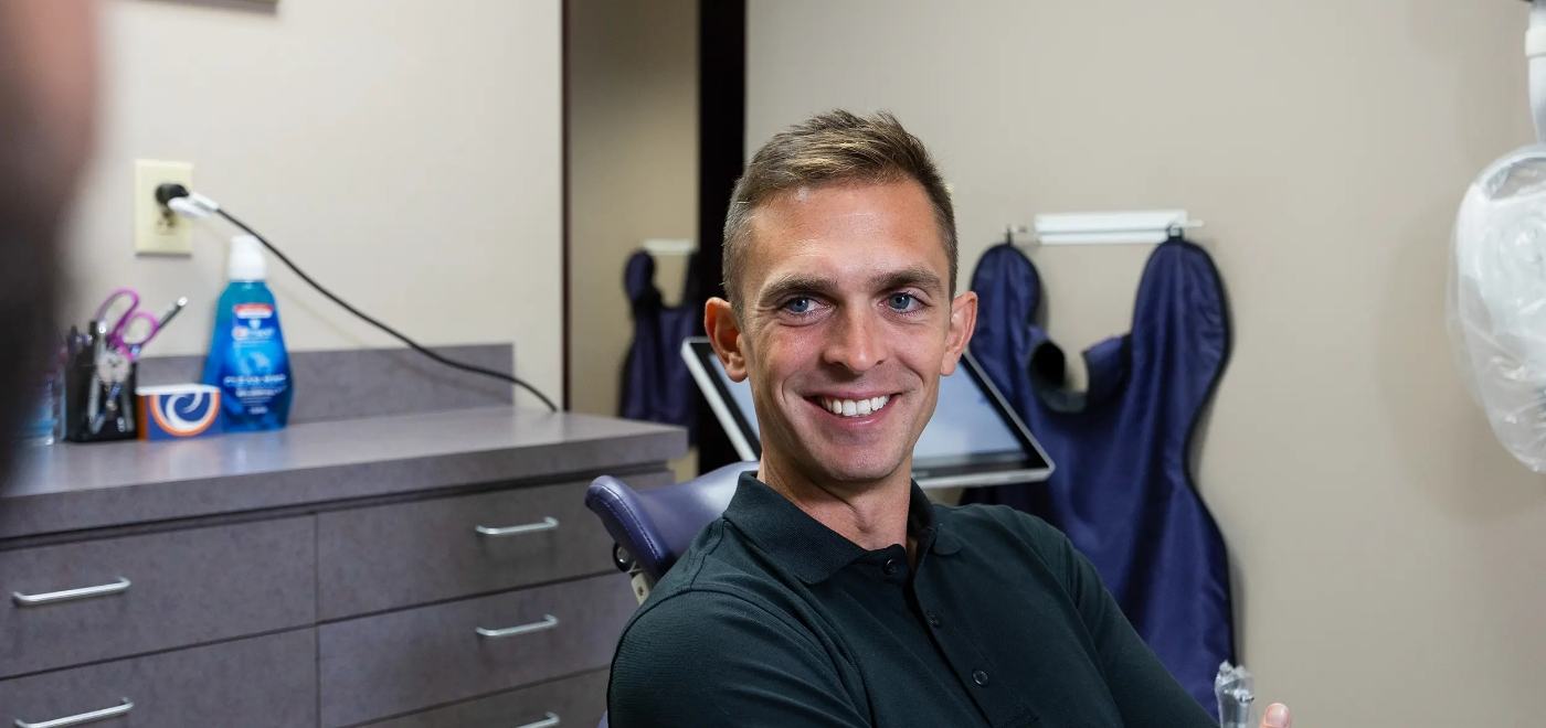 Man smiling while seeing his dentist for orthodontics in Garner
