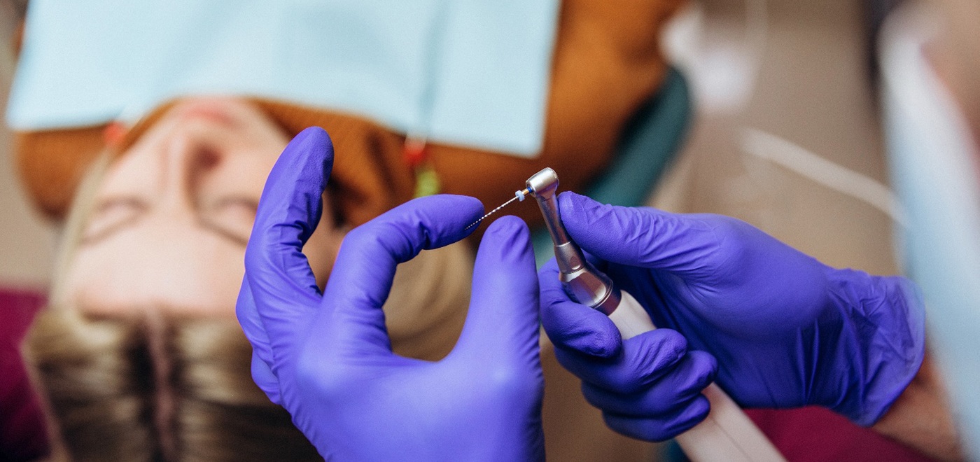Dentist preparing special instrument for woman’s root canal