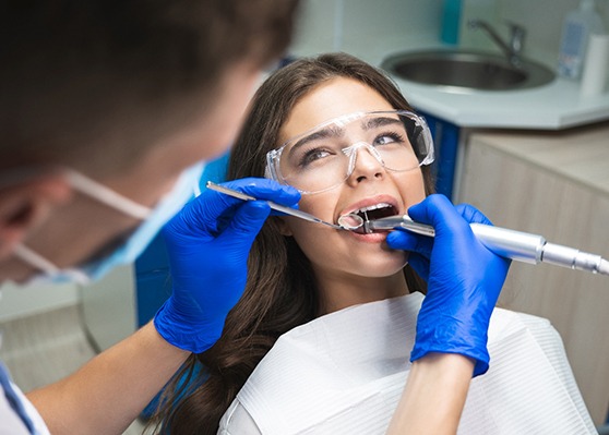 Woman in protective glasses undergoing root canal