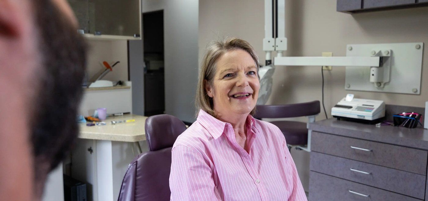 Woman smiling in dental chair after receiving dental services in Garner