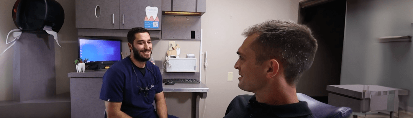 Garner dentist brushing a denture with a toothbrush