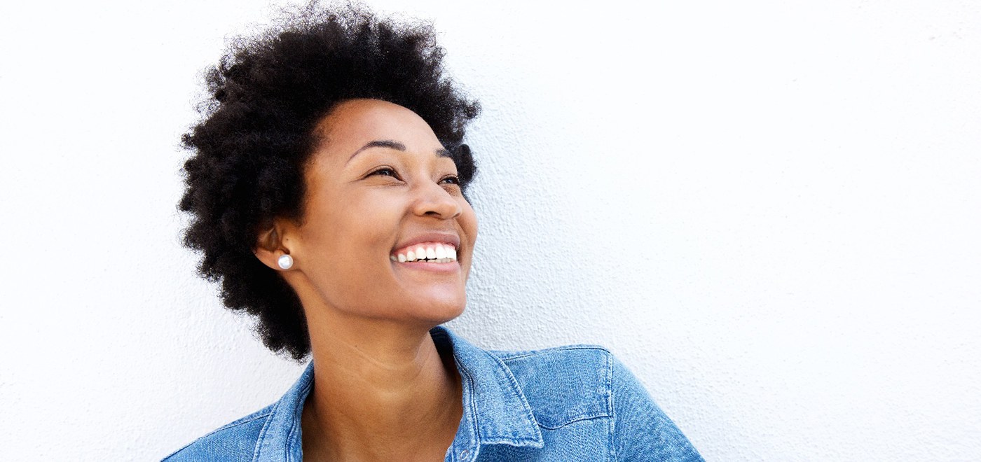 Young woman smiling happily after a visit with her UnitedHealthcare dentist in Garner
